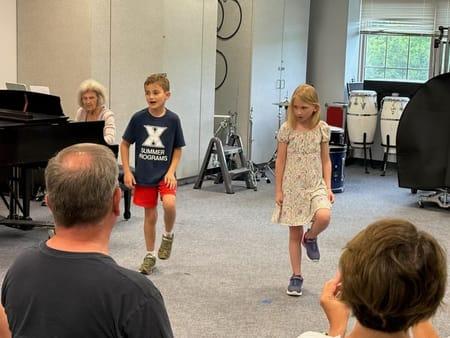 Image of kids performing with a piano behind them